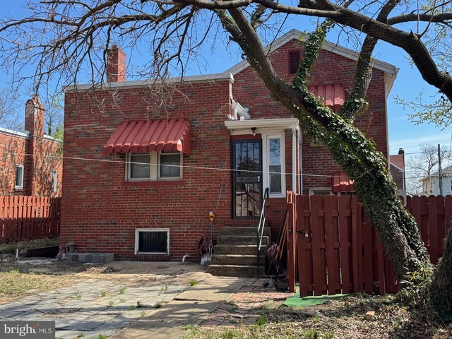 5608 1st St NE, Washington, DC 20011 - view of front of house with brick siding, entry steps, fence, and a chimney