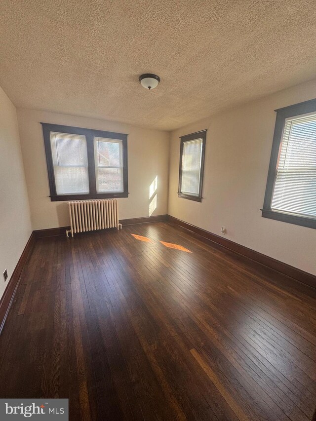 5608 1st St NE, Washington, DC 20011 - unfurnished room with baseboards, radiator, hardwood / wood-style floors, and a textured ceiling