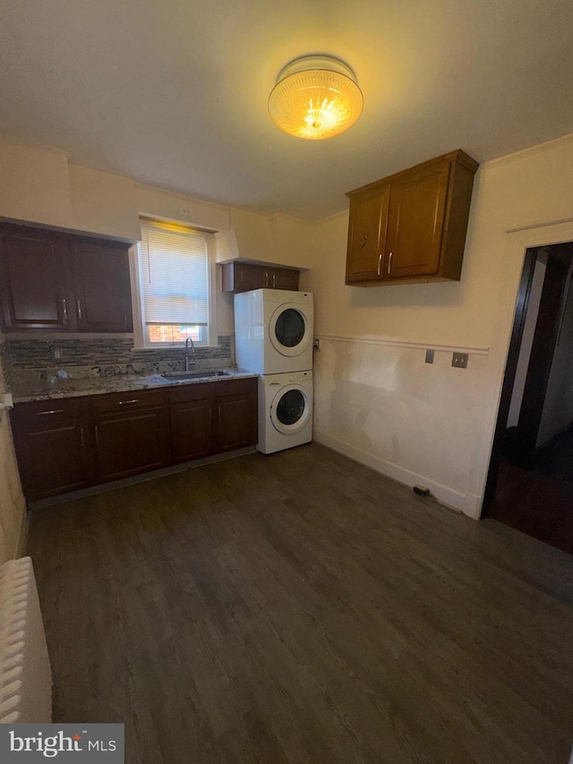 5608 1st St NE, Washington, DC 20011 - kitchen with baseboards, dark wood-style flooring, a sink, light countertops, and stacked washer / dryer