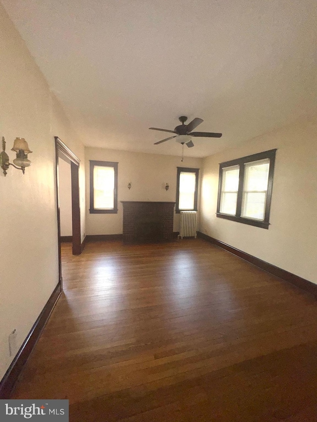 5608 1st St NE, Washington, DC 20011 - unfurnished living room featuring a wealth of natural light, radiator, ceiling fan, and wood finished floors