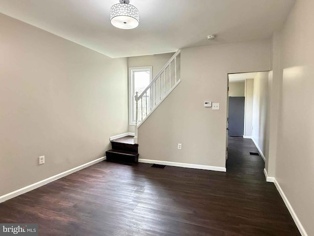 interior space featuring stairway, dark wood-style flooring, and visible vents