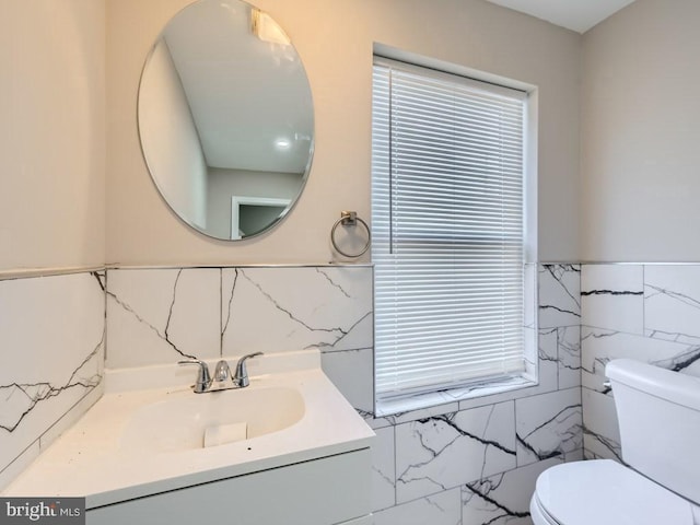 1324 W Pratt St, Baltimore, MD 21223 - half bathroom featuring tile walls, vanity, and a wainscoted wall