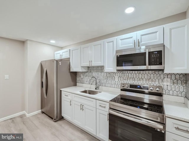 1324 W Pratt St, Baltimore, MD 21223 - kitchen featuring appliances with stainless steel finishes, light wood-type flooring, light countertops, backsplash, and recessed lighting