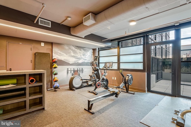 exercise room with baseboards, carpet floors, and visible vents