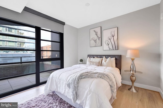 bedroom with baseboards and wood finished floors