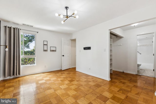 interior space with visible vents, baseboards, and an inviting chandelier