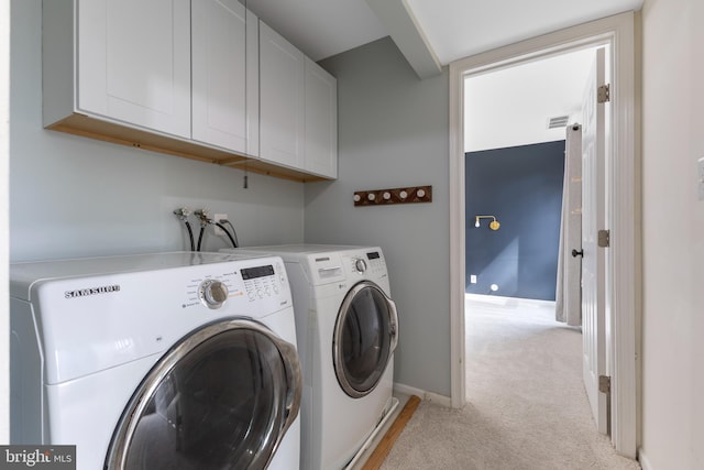 clothes washing area with visible vents, independent washer and dryer, baseboards, cabinet space, and light colored carpet