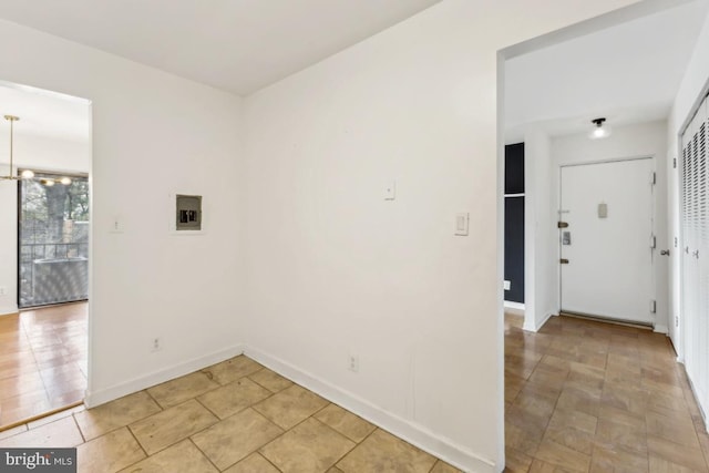 clothes washing area featuring baseboards and light tile patterned floors