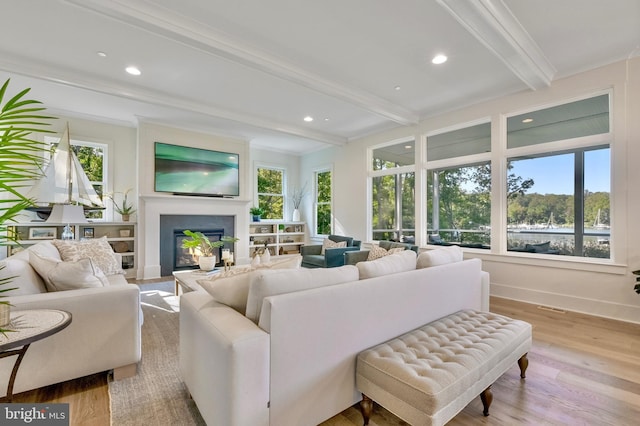 938A Benning Rd, Galesville, MD 20765 - living area featuring a glass covered fireplace, beamed ceiling, crown molding, and wood finished floors