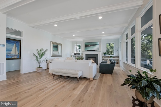 938A Benning Rd, Galesville, MD 20765 - living area with beamed ceiling, a lit fireplace, visible vents, light wood finished floors, and baseboards