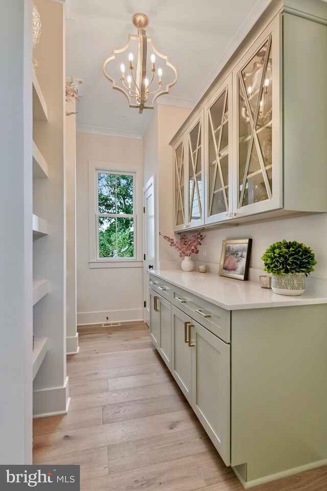 938A Benning Rd, Galesville, MD 20765 - bar featuring a notable chandelier, baseboards, crown molding, light wood finished floors, and hanging light fixtures