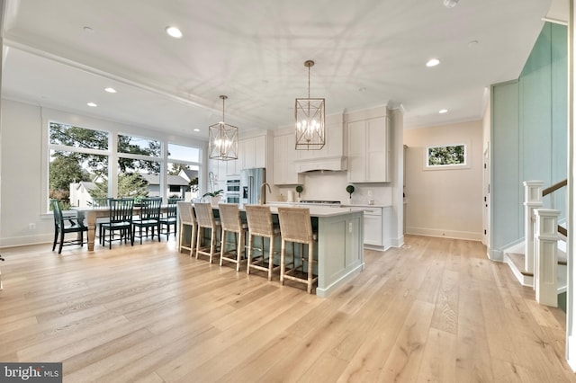 938A Benning Rd, Galesville, MD 20765 - kitchen featuring appliances with stainless steel finishes, light wood finished floors, a kitchen breakfast bar, and a wealth of natural light