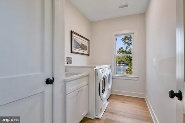 938A Benning Rd, Galesville, MD 20765 - washroom featuring separate washer and dryer, visible vents, light wood finished floors, baseboards, and cabinet space