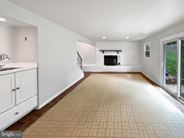 4987 Dequincey Dr, Fairfax, VA 22032 - unfurnished living room featuring baseboards, recessed lighting, stairway, a brick fireplace, and a sink