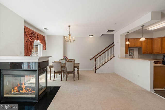 13945 Hollow Wind Way Unit 201, Woodbridge, VA 22191 - dining room featuring stairway, a multi sided fireplace, light carpet, an inviting chandelier, and visible vents