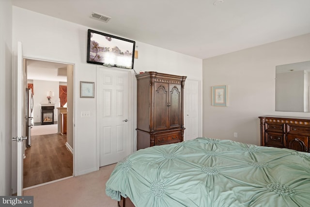 13945 Hollow Wind Way Unit 201, Woodbridge, VA 22191 - bedroom featuring freestanding refrigerator, visible vents, and light colored carpet