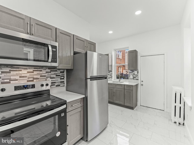 4841 N 13th St, Philadelphia, PA 19141 - kitchen with gray cabinets, marble finish floor, light countertops, radiator, and appliances with stainless steel finishes