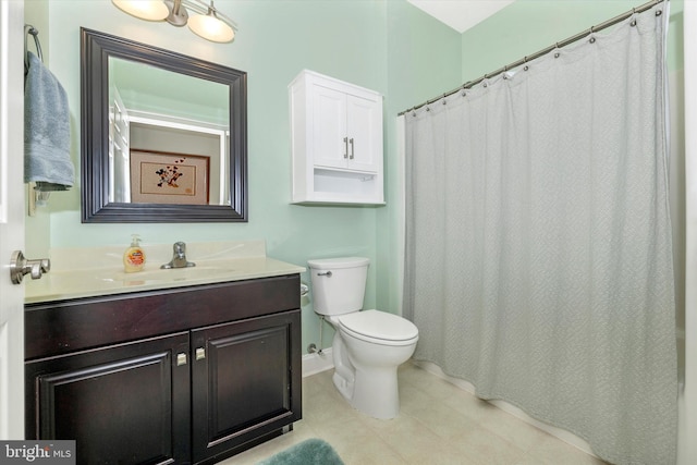 bathroom with tile patterned floors, toilet, vanity, and baseboards