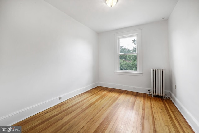 4516 13th St NW, Washington, DC 20011 - empty room with radiator heating unit, light wood finished floors, and baseboards