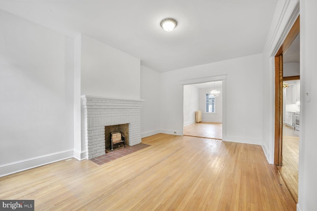 4516 13th St NW, Washington, DC 20011 - unfurnished living room featuring a chandelier, light wood-style floors, baseboards, and radiator heating unit
