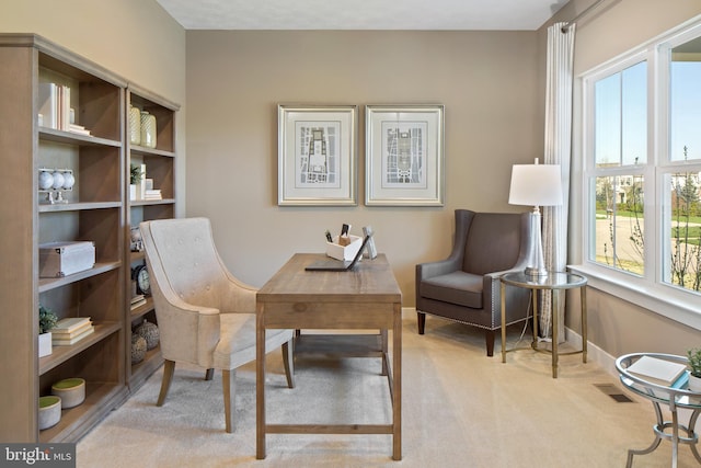 office space with a wealth of natural light, baseboards, carpet flooring, and visible vents