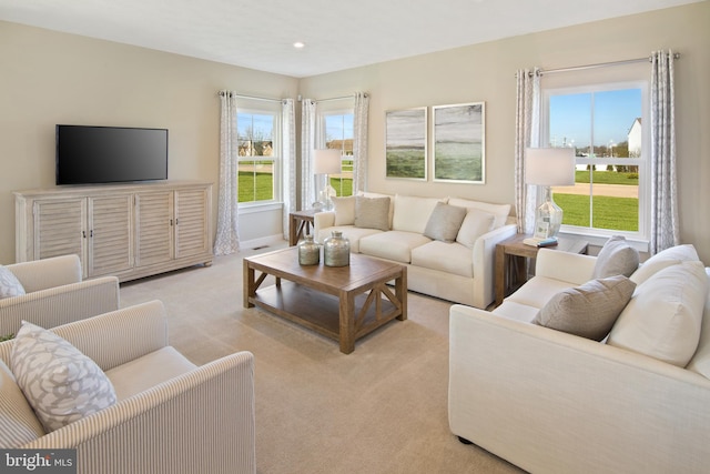 living area with light carpet, baseboards, and recessed lighting