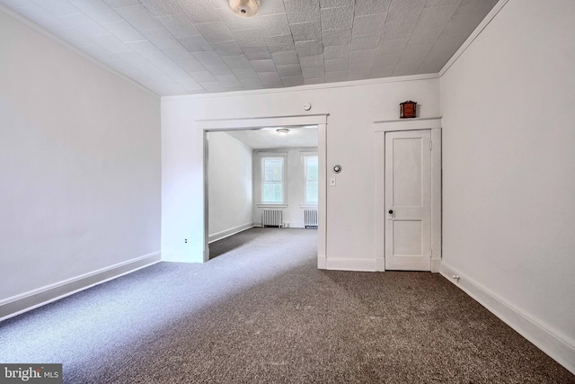 carpeted spare room featuring radiator, baseboards, and ornamental molding