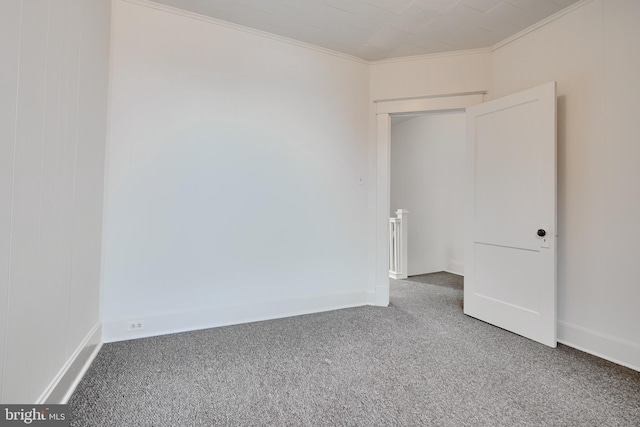 carpeted empty room featuring ornamental molding and baseboards