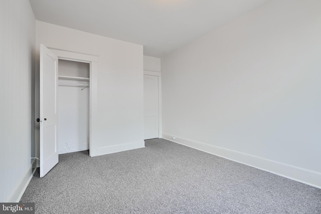 unfurnished bedroom featuring a closet, carpet flooring, and baseboards