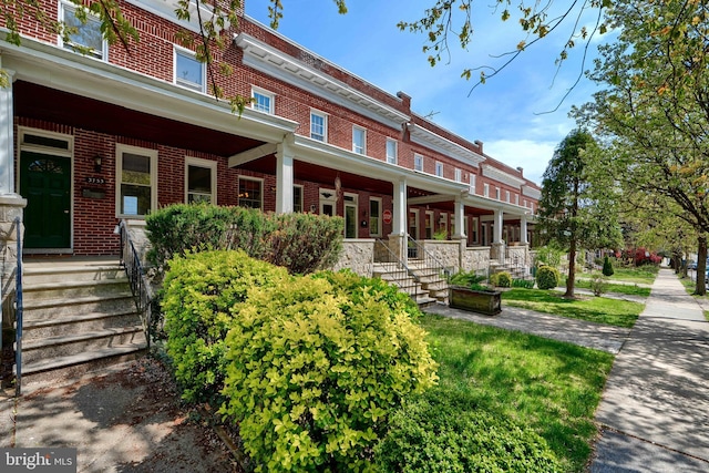 exterior space featuring brick siding and a porch