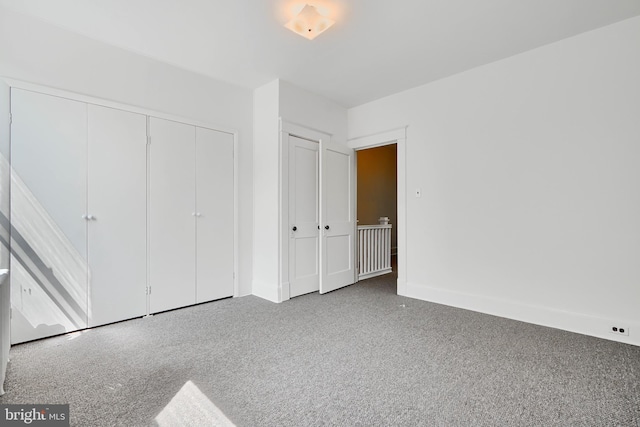 unfurnished bedroom featuring carpet, a closet, and baseboards