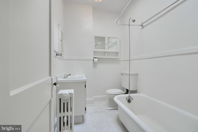 full bathroom with vanity, tile patterned flooring, toilet, a tub to relax in, and tile walls