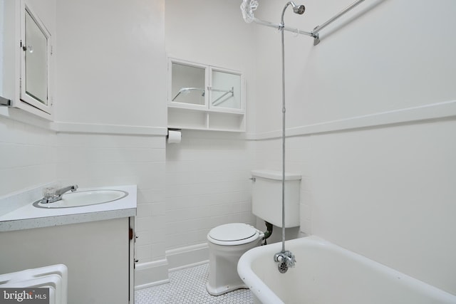 bathroom with toilet, tile patterned flooring, a bath, and vanity