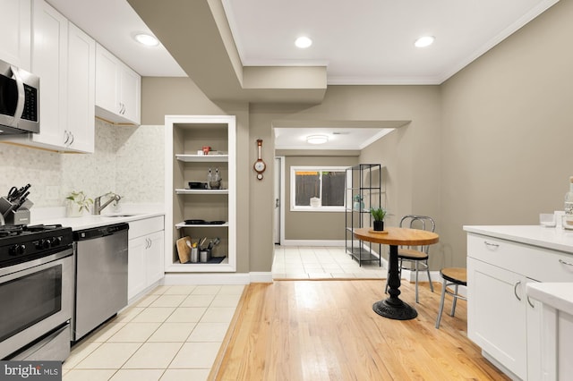 1936 Capitol Ave NE, Washington, DC 20002 - kitchen with appliances with stainless steel finishes, light countertops, white cabinetry, ornamental molding, and recessed lighting