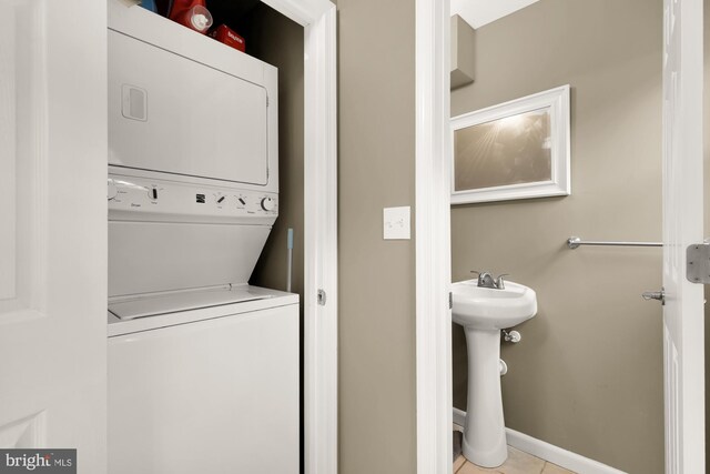 1936 Capitol Ave NE, Washington, DC 20002 - washroom featuring stacked washer and clothes dryer, light tile patterned floors, and baseboards