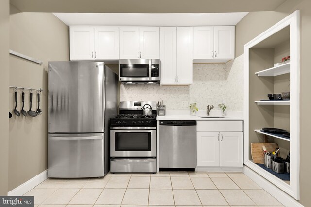 1936 Capitol Ave NE, Washington, DC 20002 - kitchen with stainless steel appliances, white cabinets, tasteful backsplash, light countertops, and light tile patterned floors