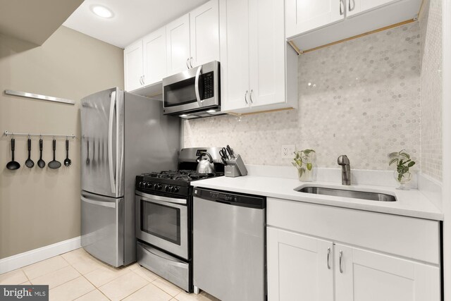 1936 Capitol Ave NE, Washington, DC 20002 - kitchen with stainless steel appliances, a sink, light tile patterned floors, white cabinets, and light countertops