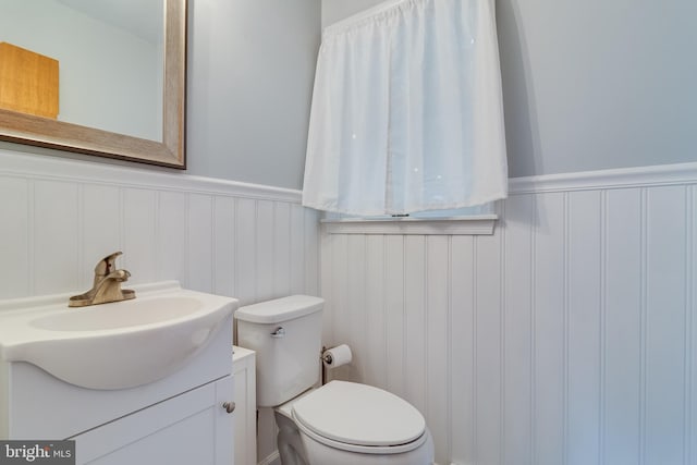 36035 Army Navy Dr, Mechanicsville, MD 20659 - bathroom featuring vanity, toilet, wainscoting, and a decorative wall