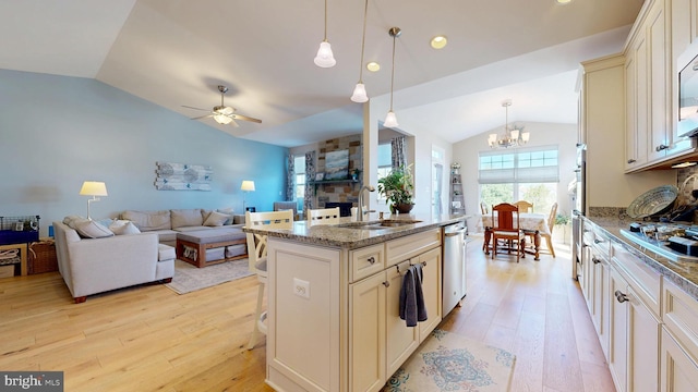 kitchen with lofted ceiling, a sink, cream cabinetry, and light wood-type flooring