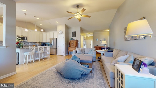 living area with vaulted ceiling, recessed lighting, light wood-style floors, and ceiling fan