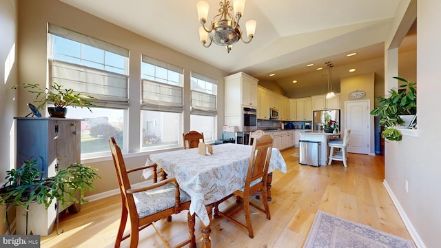 dining space with a chandelier, lofted ceiling, baseboards, and light wood-style flooring