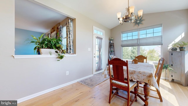 dining area with vaulted ceiling, baseboards, a chandelier, and wood finished floors