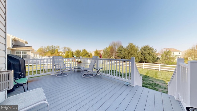 wooden deck featuring fence, grilling area, and a yard