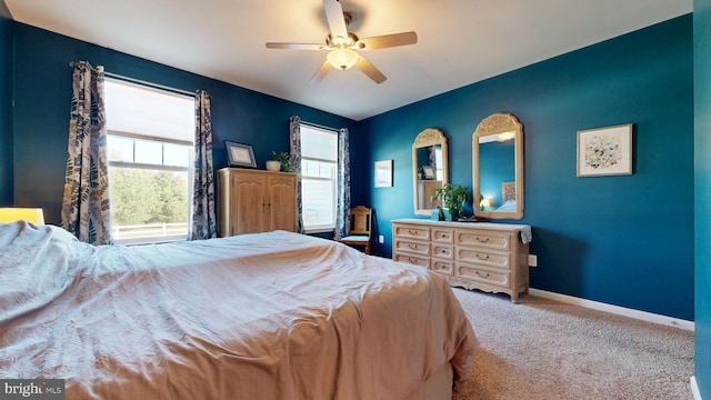 bedroom with a ceiling fan, baseboards, and carpet floors