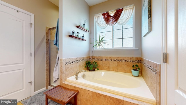 bathroom featuring a shower stall and a garden tub
