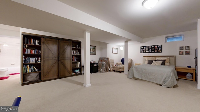 bedroom with ensuite bathroom, baseboards, and carpet