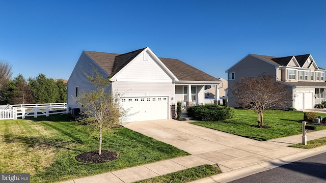 traditional home with fence, driveway, a front yard, and a garage