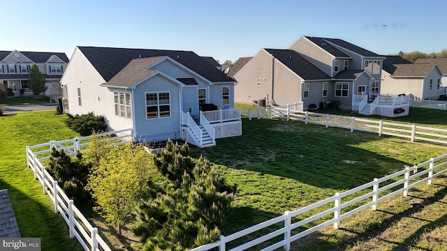 exterior space featuring stairway, a lawn, a fenced backyard, and a residential view