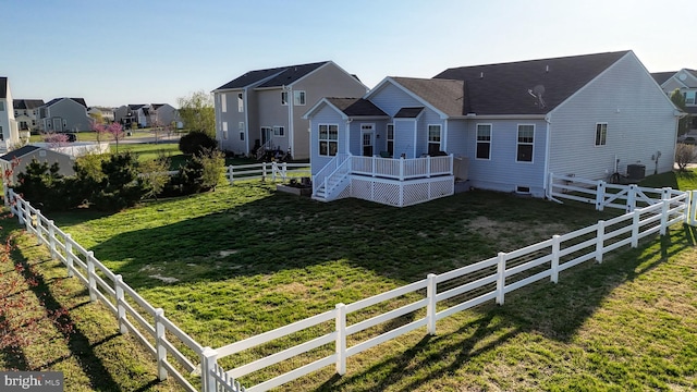 rear view of house featuring a residential view, central AC, a wooden deck, a lawn, and crawl space