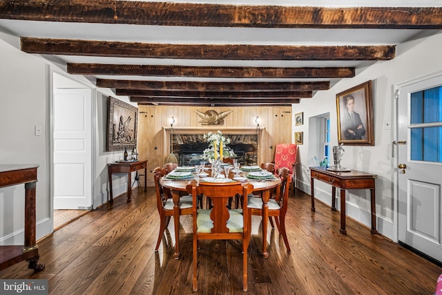dining area featuring beamed ceiling, baseboards, and dark wood-style floors